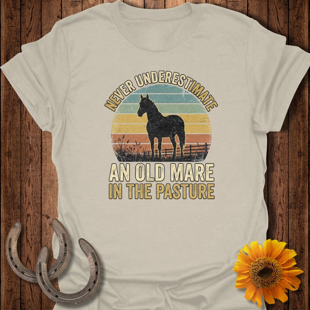 T-shirt with horse silhouette against sunset and text "Never Underestimate An Old Mare In The Pasture".