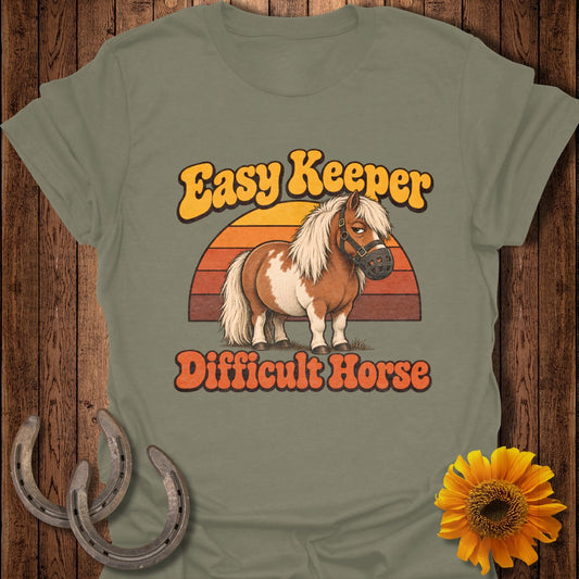 Brown and white pony with a muzzle, text "Easy Keeper Difficult Horse"