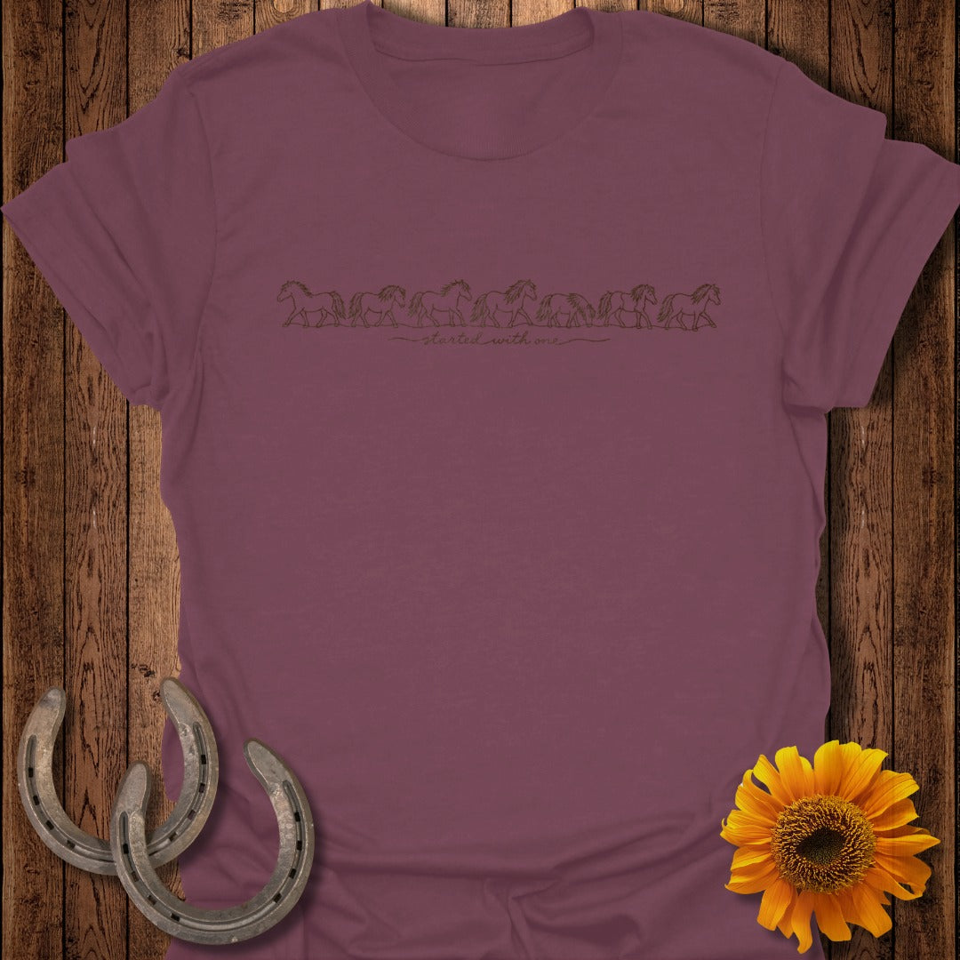 Maroon t-shirt with line drawing of running horses and text "started with one".