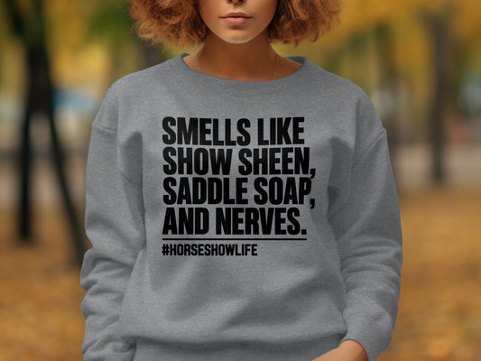 Grey sweatshirt with black text reading "Smells Like Show Sheen, Saddle Soap, And Nerves. #Horseshowlife"