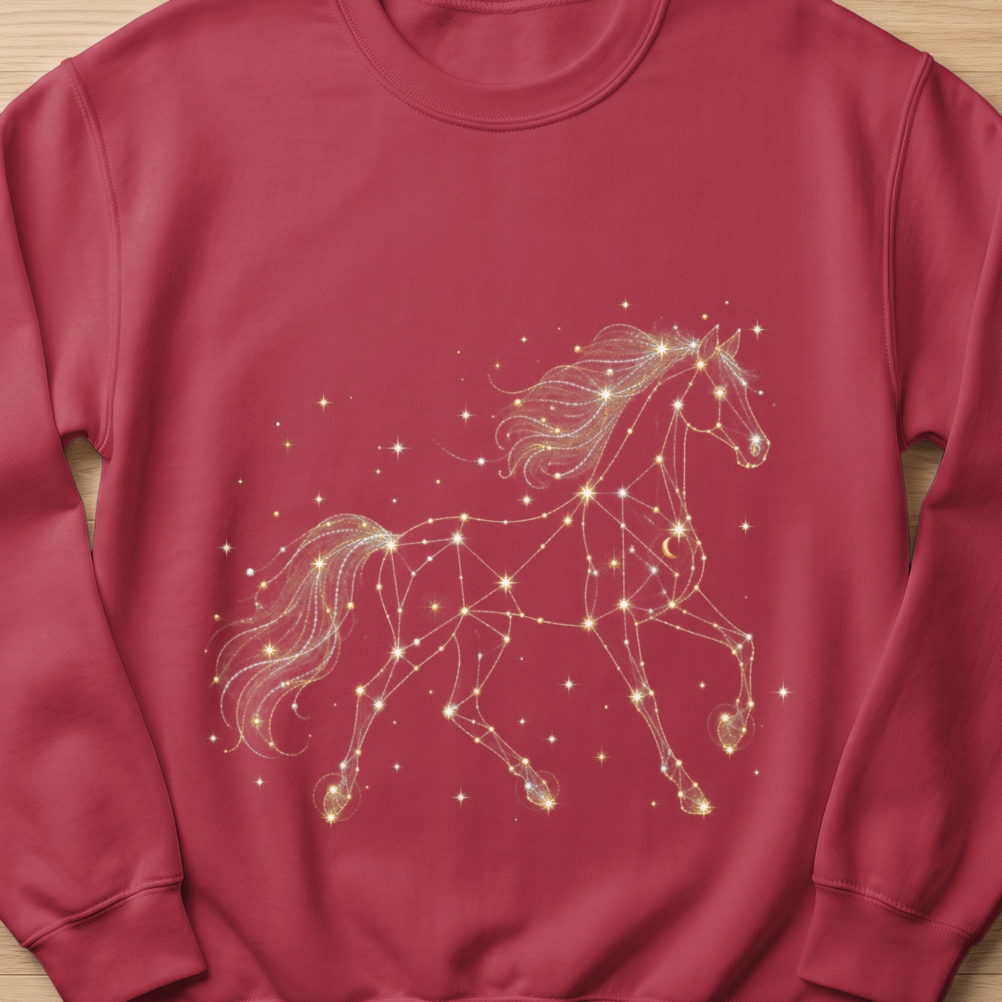 Red crewneck sweatshirt with a gold constellation horse and stars graphic.