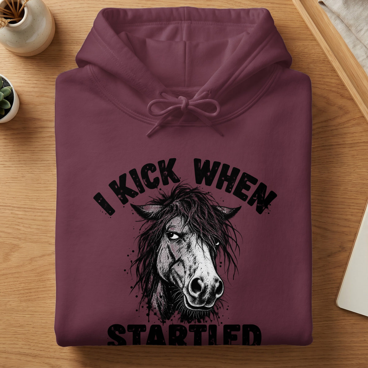 Maroon hoodie with a distressed horse graphic and text: "I KICK WHEN STARTLED".