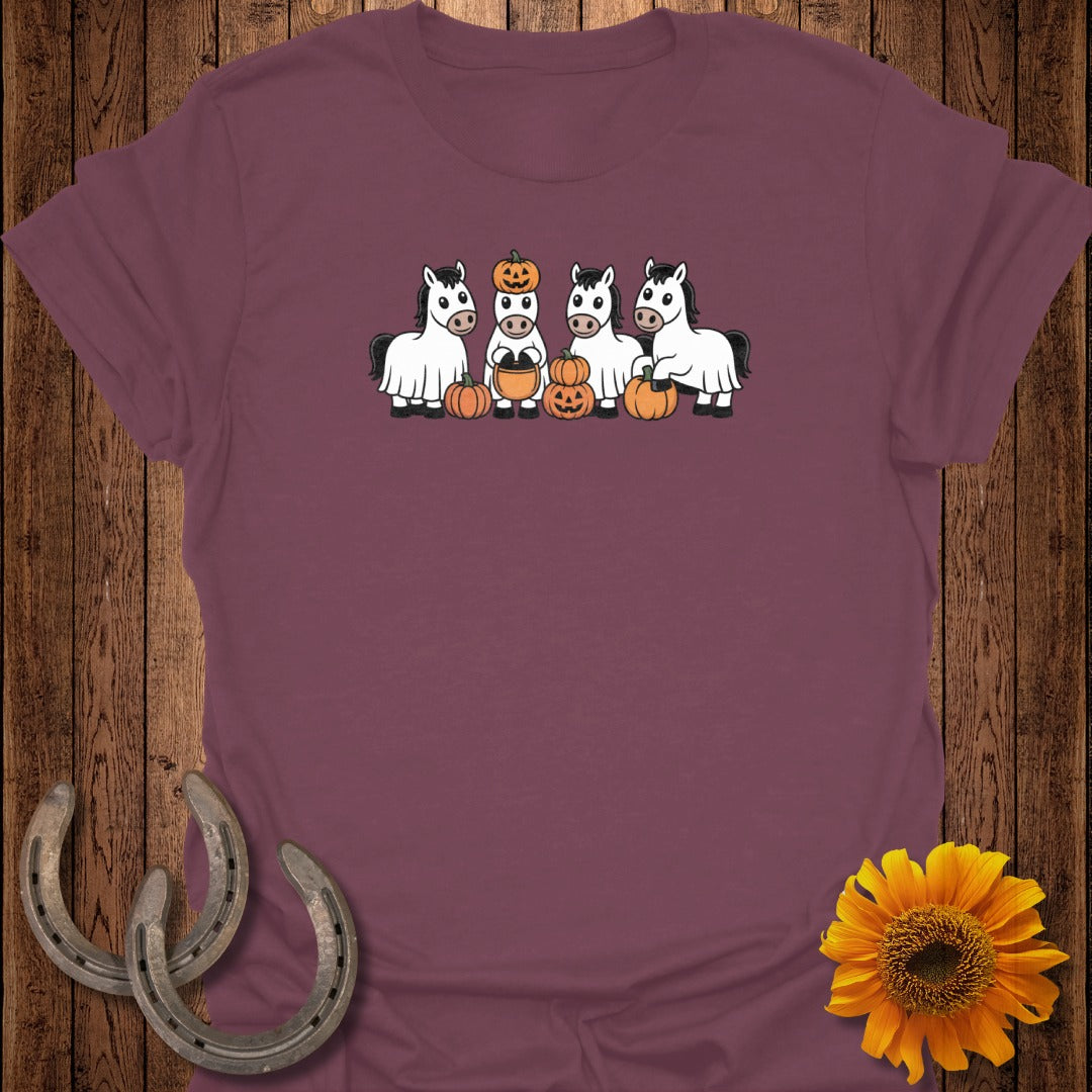 Four cartoon horses dressed as ghosts stand with pumpkins for Halloween.