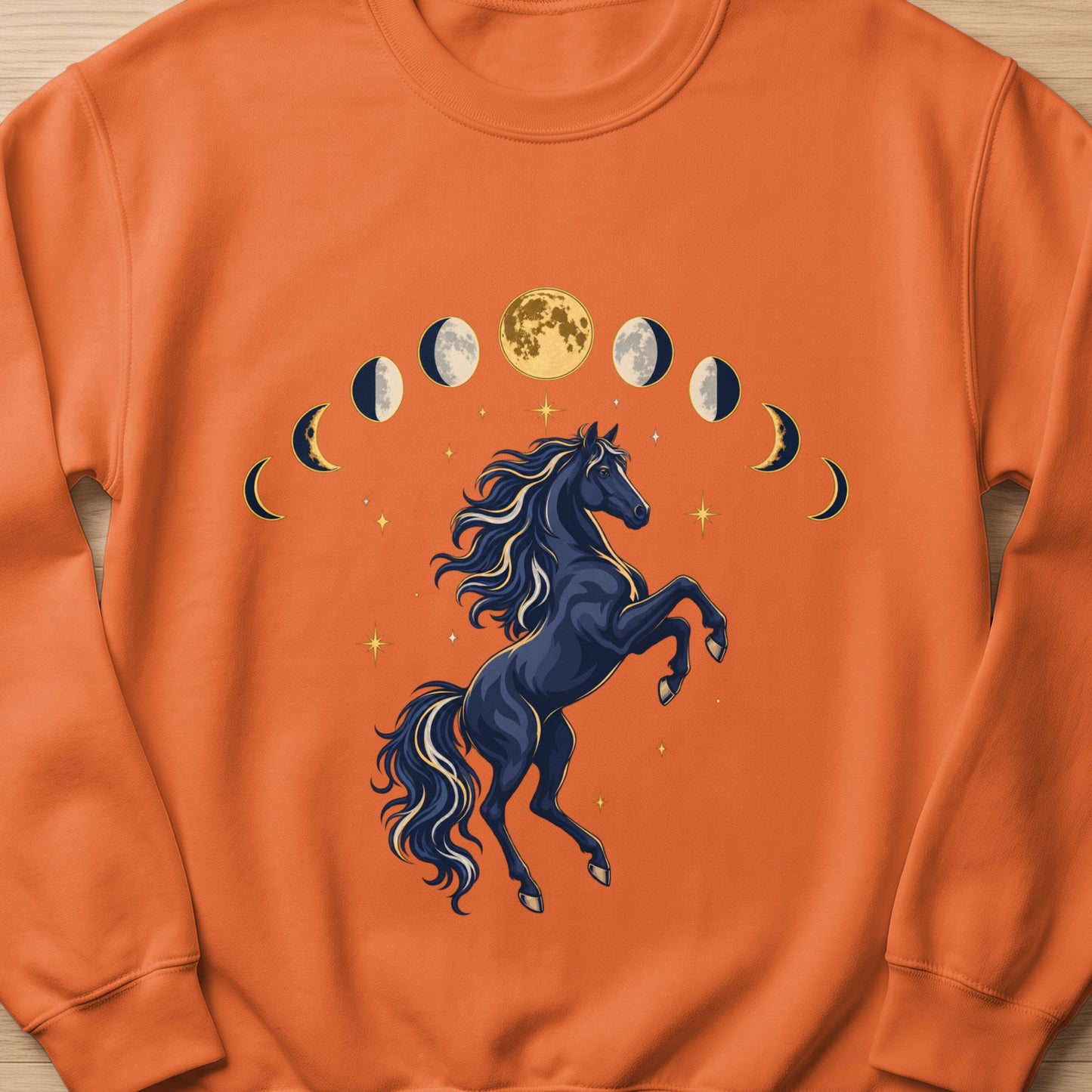 Dark blue horse rearing with moon phases and stars on an orange sweatshirt.