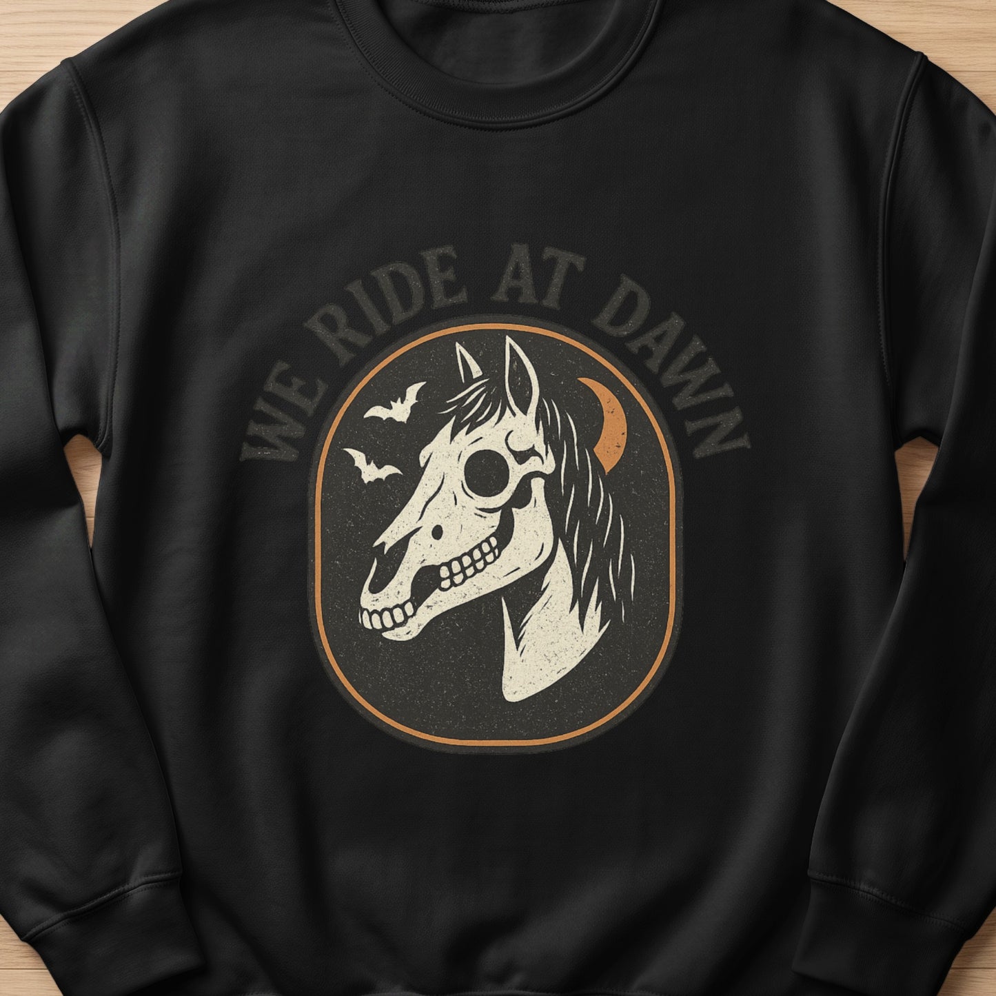 Black sweatshirt with "We Ride At Dawn" text and a horse skull graphic.