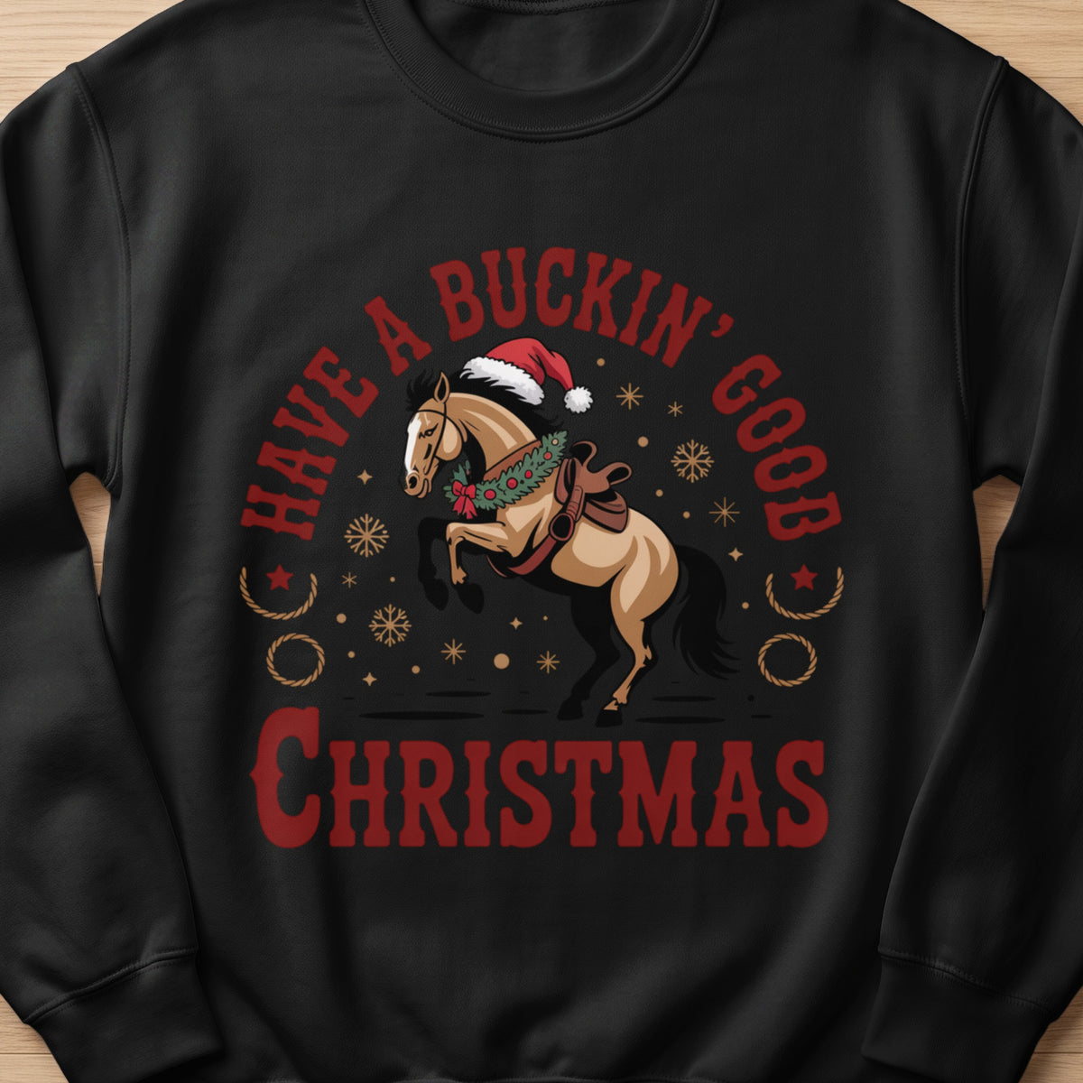 Christmas sweatshirt with a bucking horse wearing a Santa hat and wreath, reading "Have a Buckin' Good Christmas".