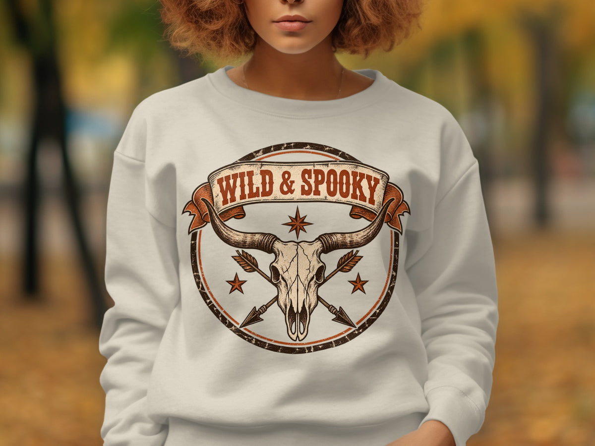 White sweatshirt with a circular bull skull graphic and "WILD & SPOOKY" text.