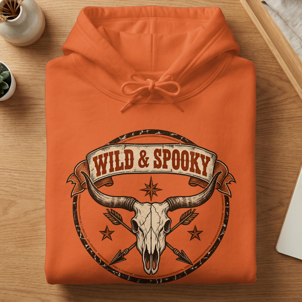 Orange hoodie with "Wild & Spooky" text over a skull and horns graphic.