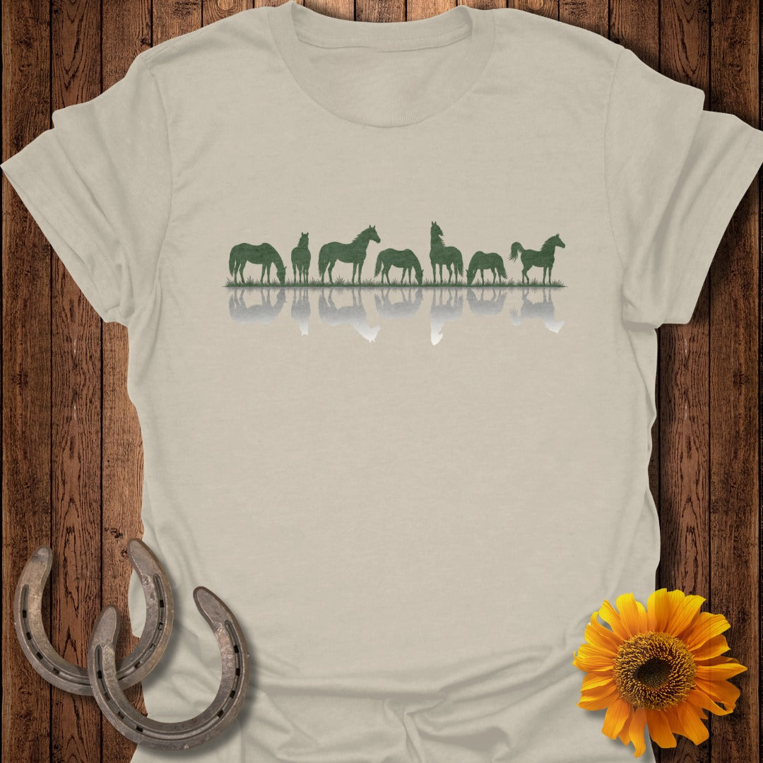 Green horse silhouettes of various sizes reflected on a light beige t-shirt.