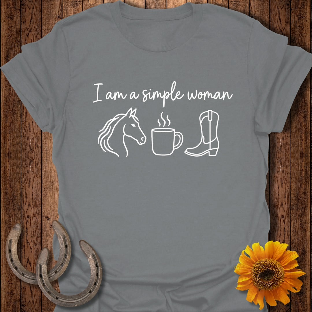A grey short-sleeve t-shirt with white text reading "I am a simple woman" above icons of a horse head, a steaming coffee mug, and a cowboy boot.