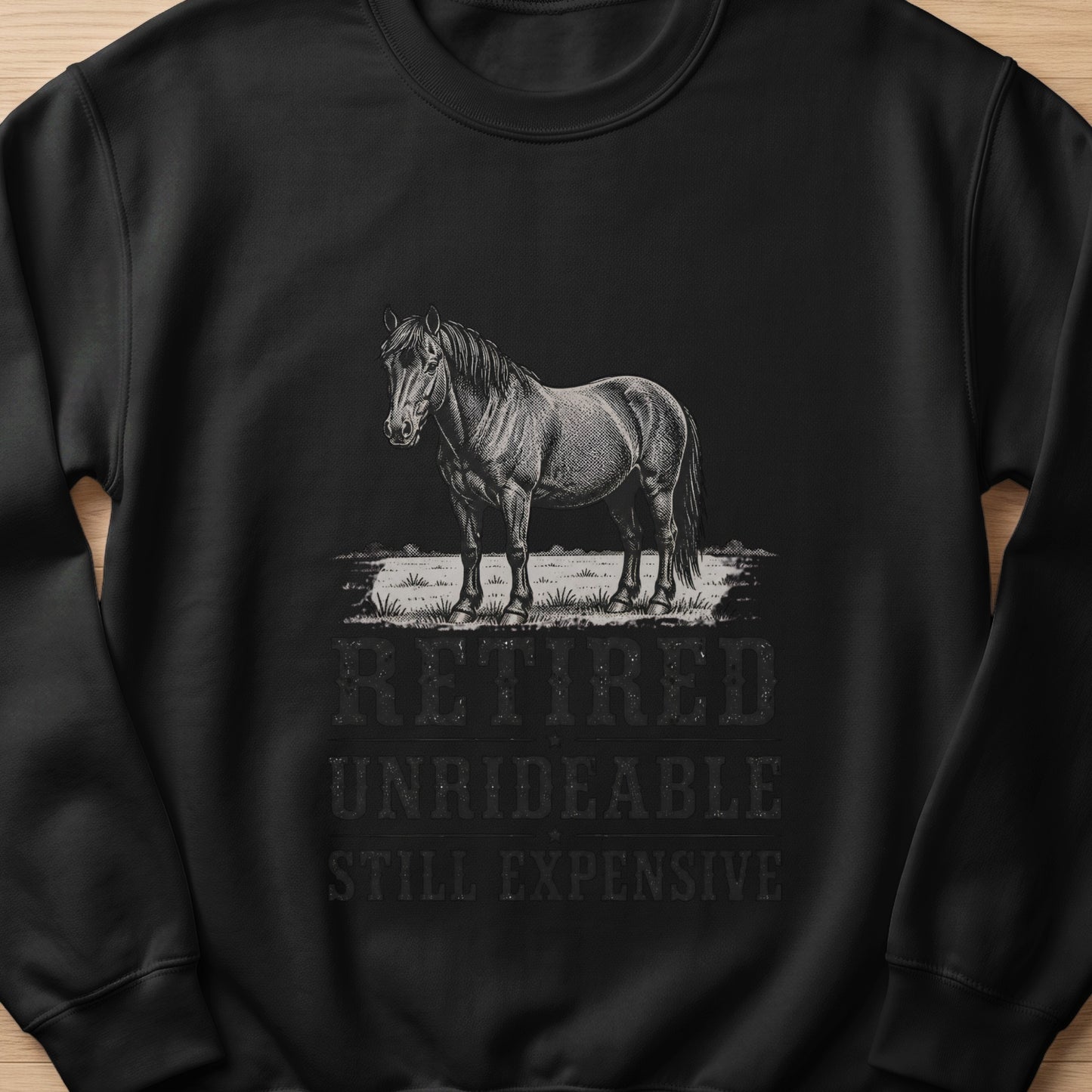 Black sweatshirt with a horse graphic and text "Retired Unrideable Still Expensive."