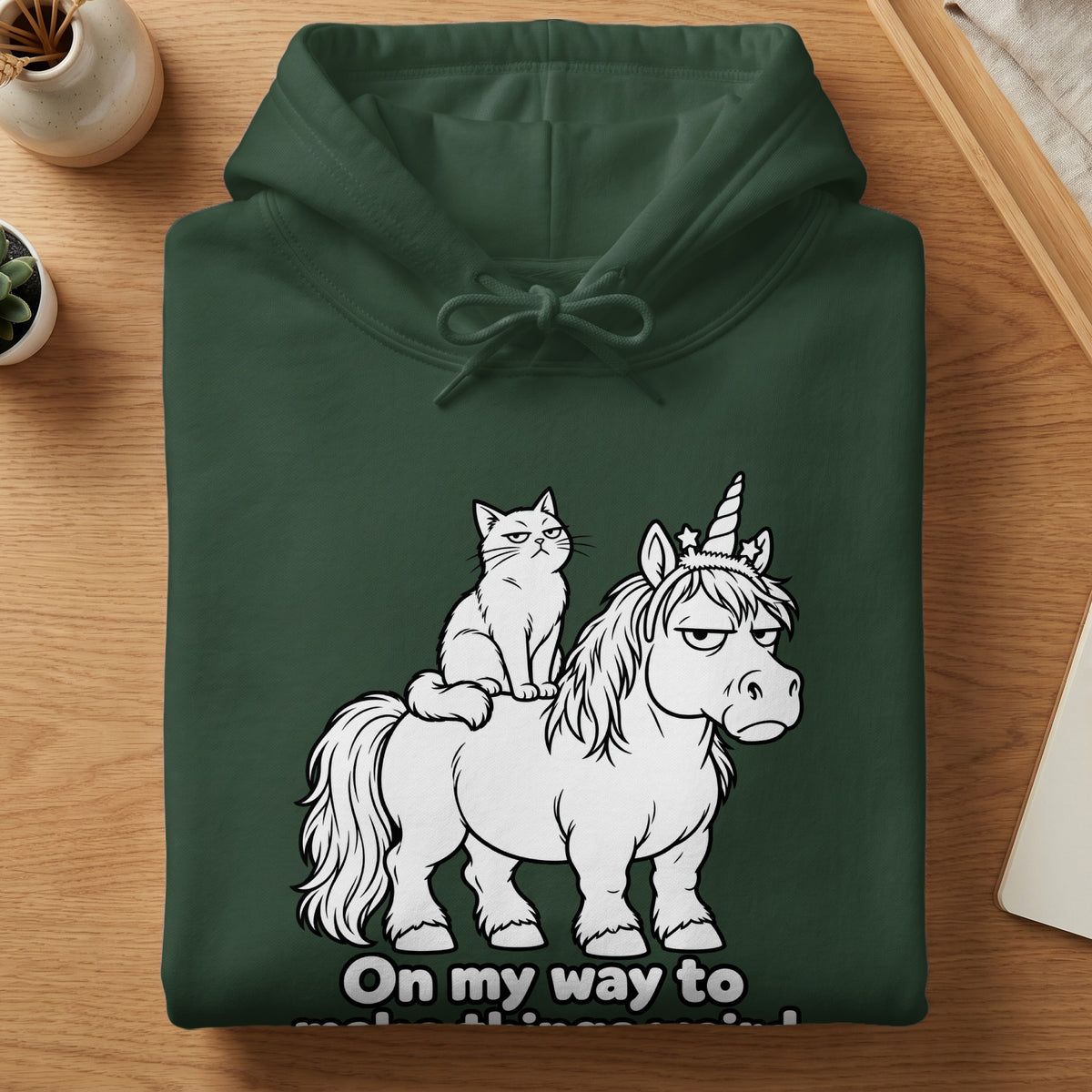 Green hoodie with a grumpy cat riding a unicorn illustration and text.
