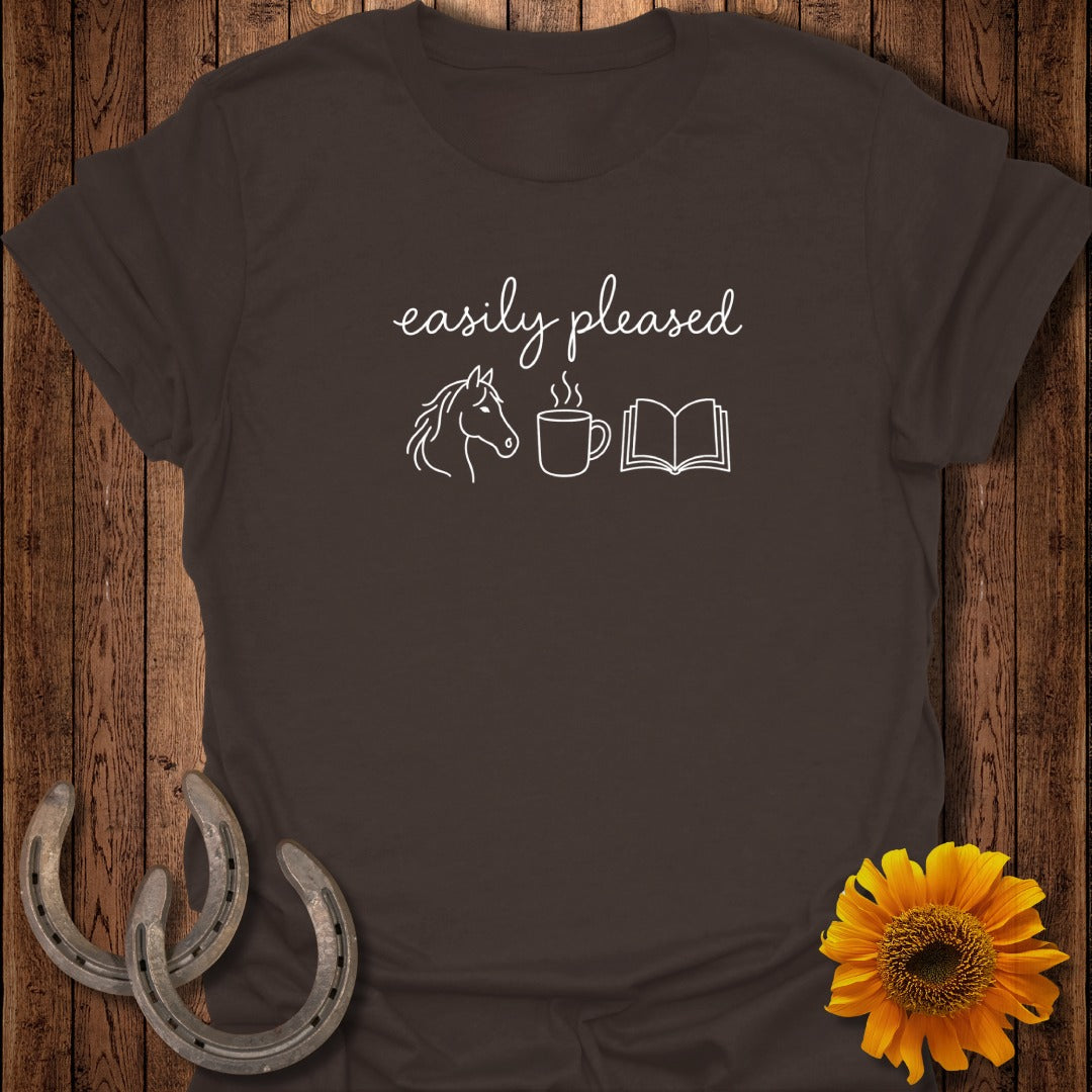 Dark brown t-shirt featuring the white text "easily pleased" above a horse head, a coffee mug, and an open book.