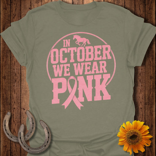 Olive green t-shirt with pink text "In October We Wear Pink" and a horse graphic.