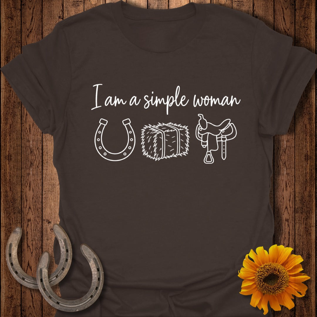 A brown t-shirt featuring white text that reads I am a simple woman alongside icons of a horseshoe, hay bale, and saddle.