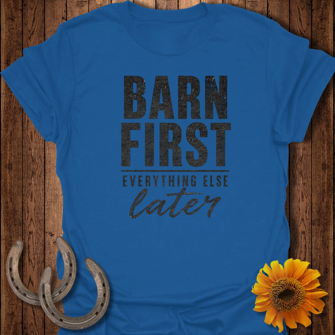 Blue t-shirt with "Barn First, Everything Else Later" text and horseshoe and sunflower accents.