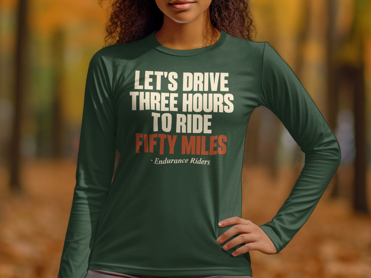 A person wearing a dark green long-sleeve shirt with the text "LET'S DRIVE THREE HOURS TO RIDE FIFTY MILES" and "- Endurance Riders" printed on the front.