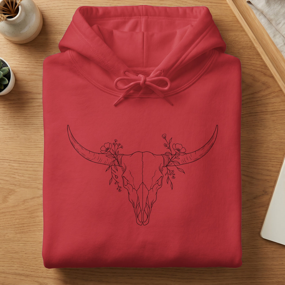 Red hoodie with a black line drawing of a floral bull skull graphic.