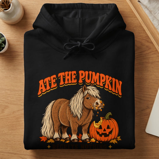 Black hoodie with a graphic of a pony eating a pumpkin and text "ATE THE PUMPKIN REGRETS NOTHING".