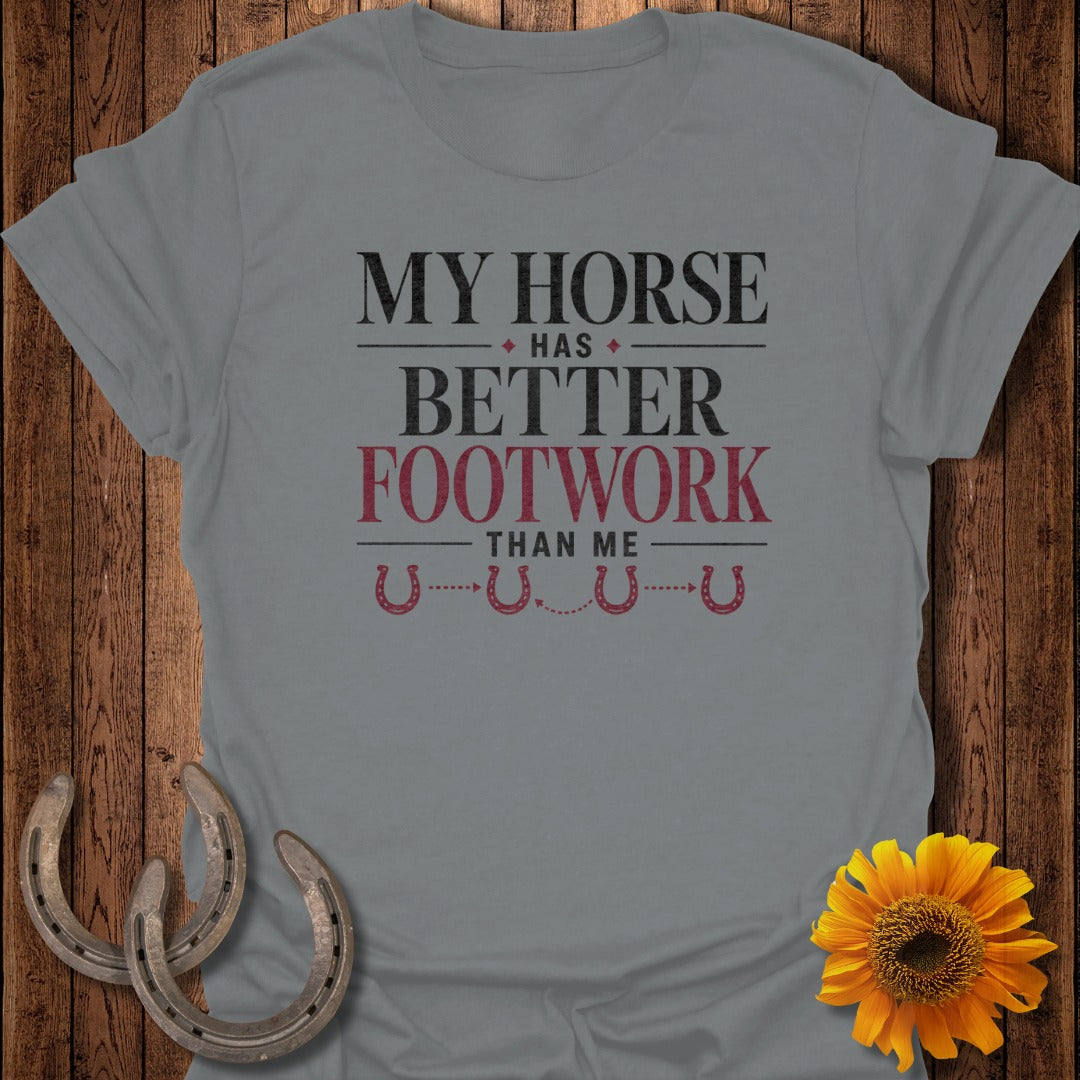 Grey t-shirt with "My Horse Has Better Footwork Than Me" text and horseshoes.