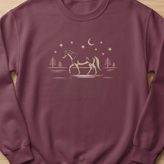 Maroon sweatshirt with graphic of horse, trees, moon, and stars. Text reads "Peaceful Plains a western christmas".