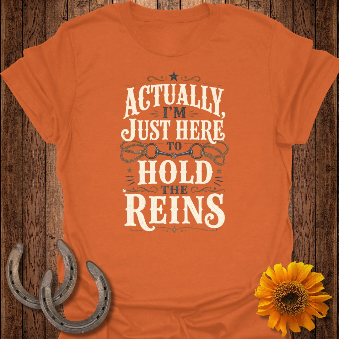 Orange t-shirt with "Actually I'm Just Here To Hold The Reins" text and horse bit graphic.