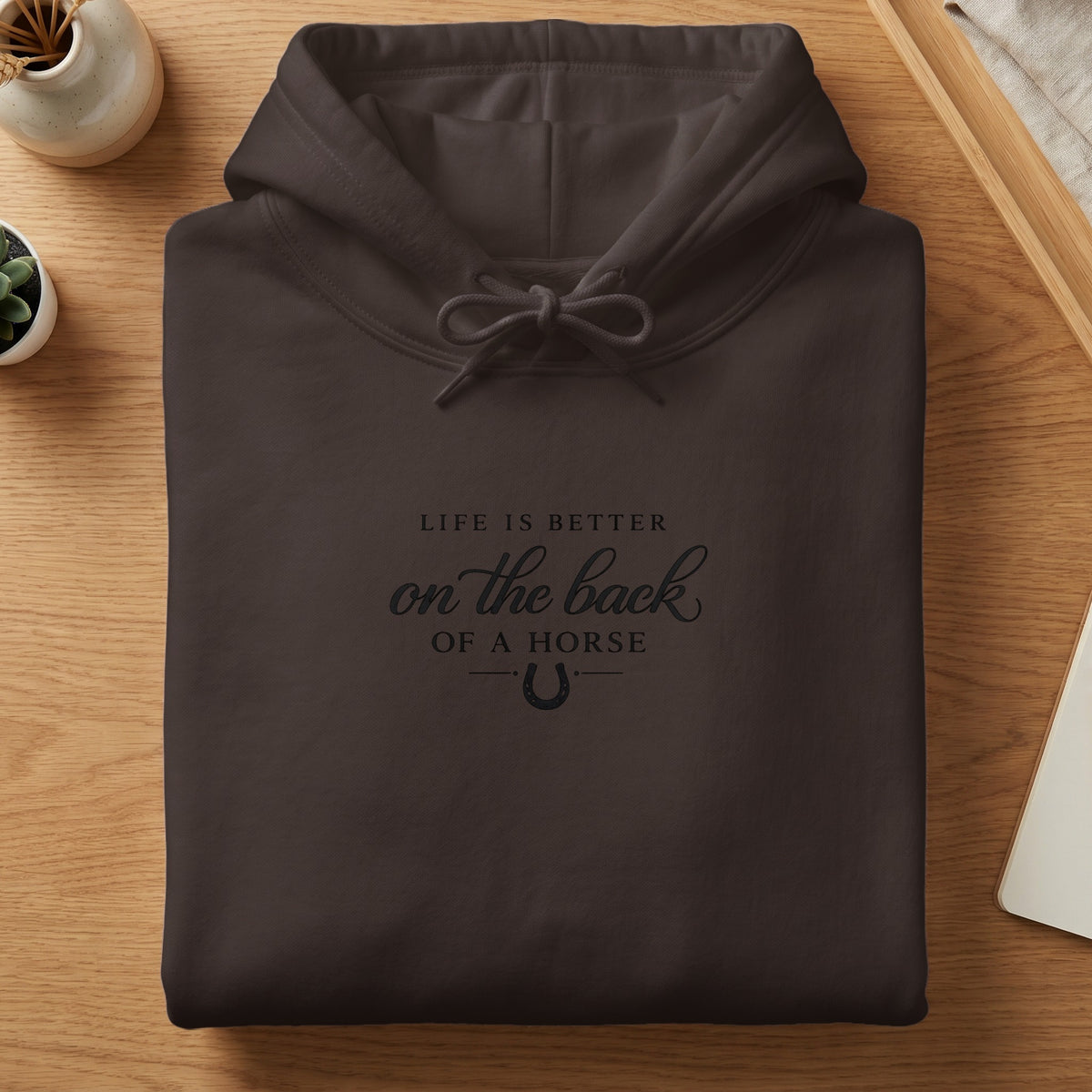 Dark brown hoodie with text "Life is better on the back of a horse" and horseshoe.