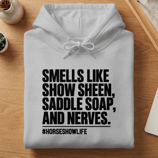 White hoodie with text "SMELLS LIKE SHOW SHEEN, SADDLE SOAP, AND NERVES. #HORSESHOWLIFE"