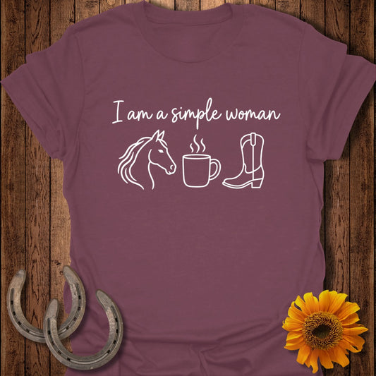 Maroon t-shirt with white text reading I am a simple woman, accompanied by line art of a horse head, a steaming coffee mug, and a cowboy boot.
