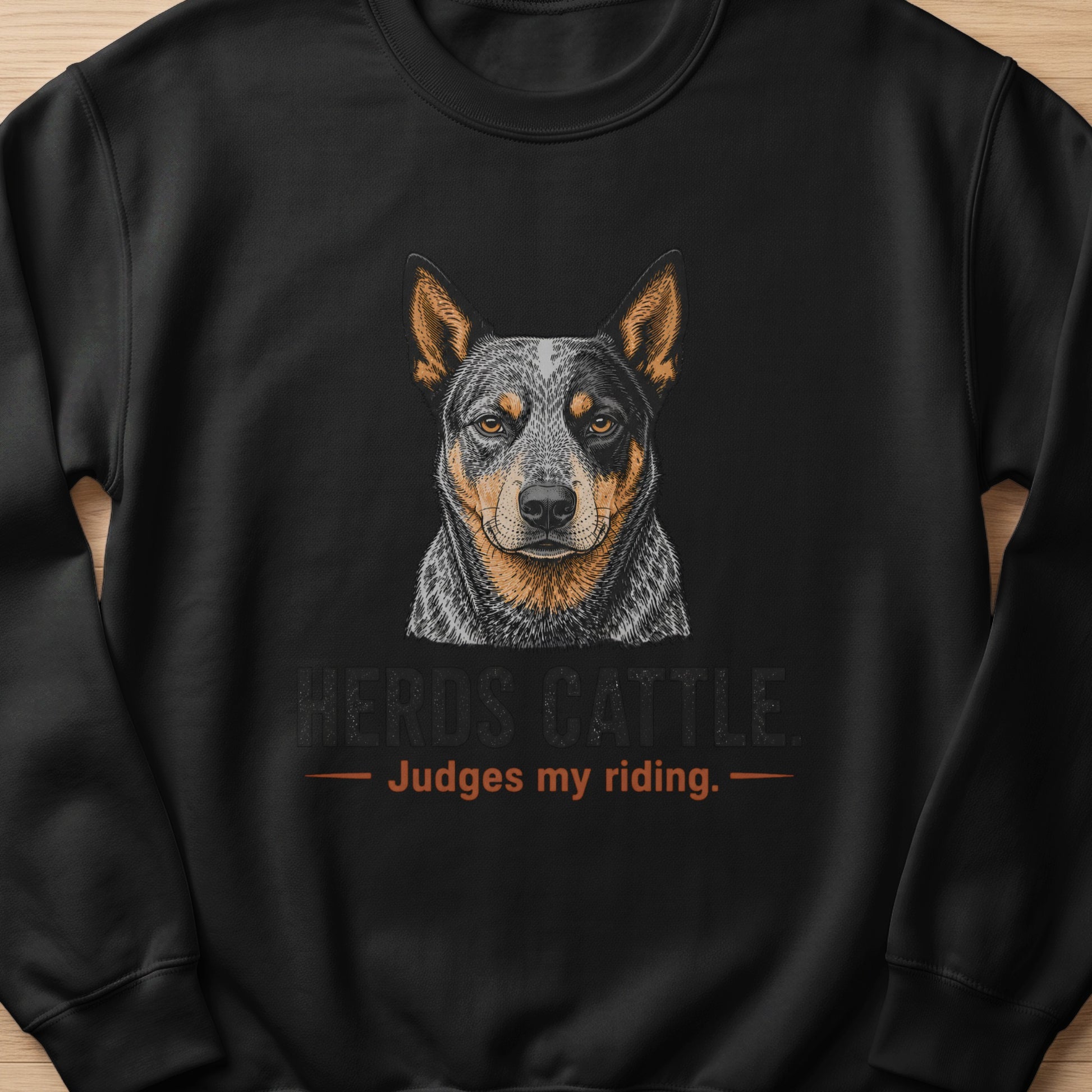 Black sweatshirt with an Australian Cattle Dog portrait and text "HERDS CATTLE. Judges my riding."