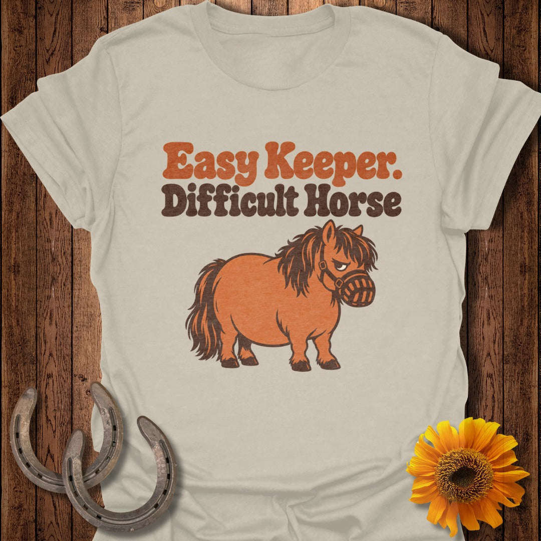 "Easy Keeper. Difficult Horse." text above a cartoon pony wearing a muzzle.