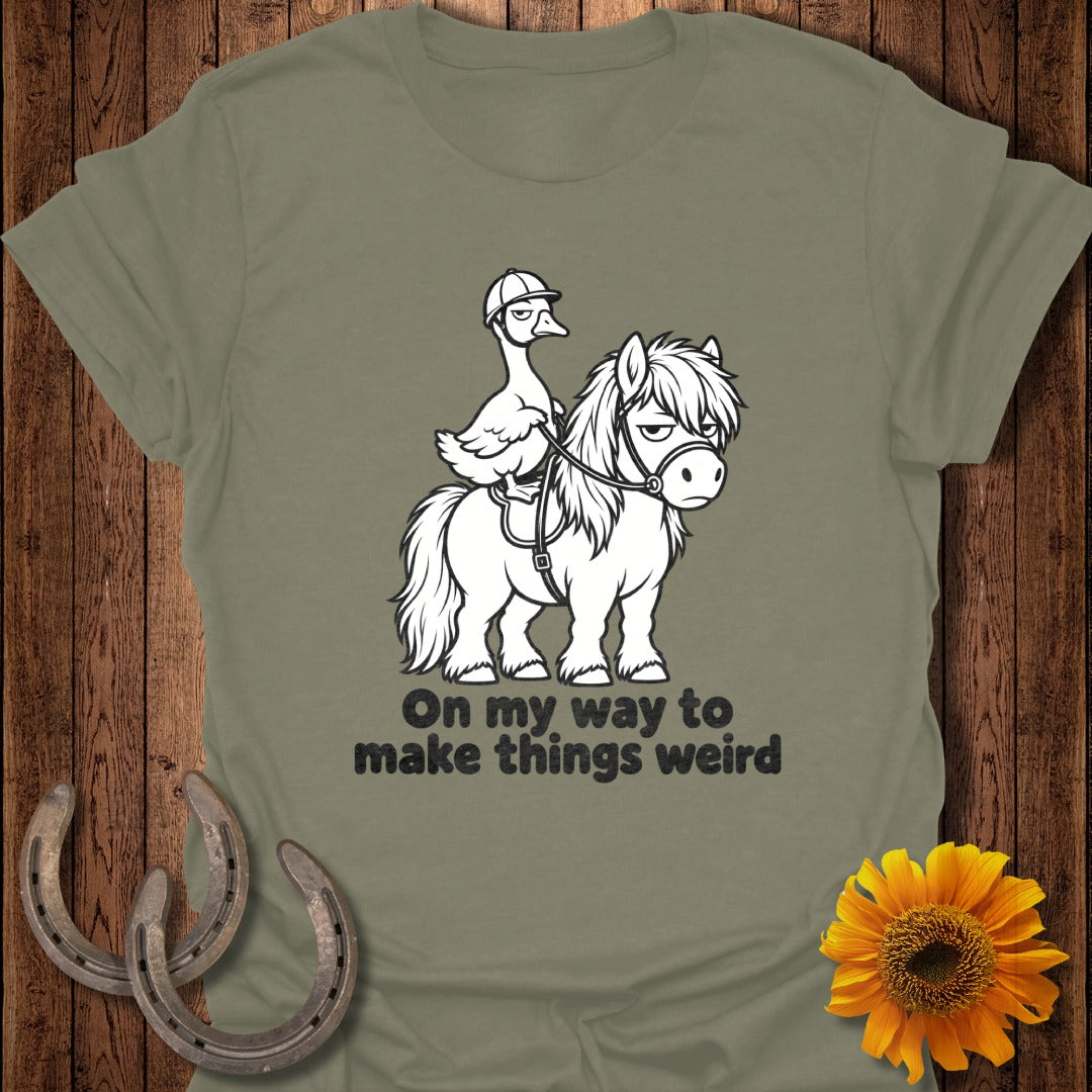 An olive green t-shirt featuring a graphic of a duck riding a pony with the text "On my way to make things weird".