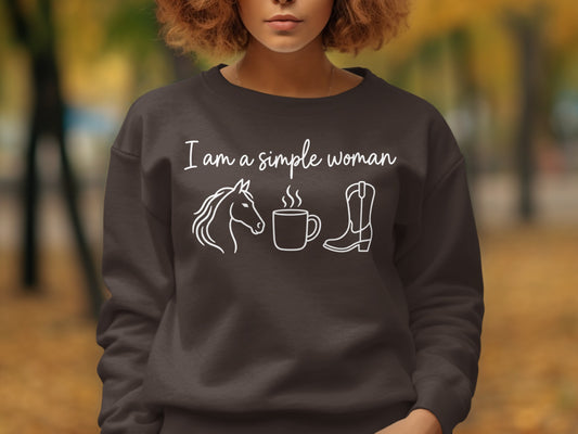 Brown sweatshirt with white text "I am a simple woman" and line art of a horse, coffee cup, and cowboy boot.