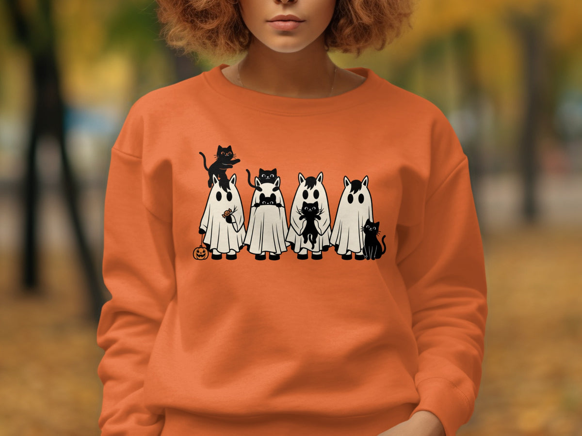 Orange sweatshirt with cartoon ghosts and black cats in Halloween theme.