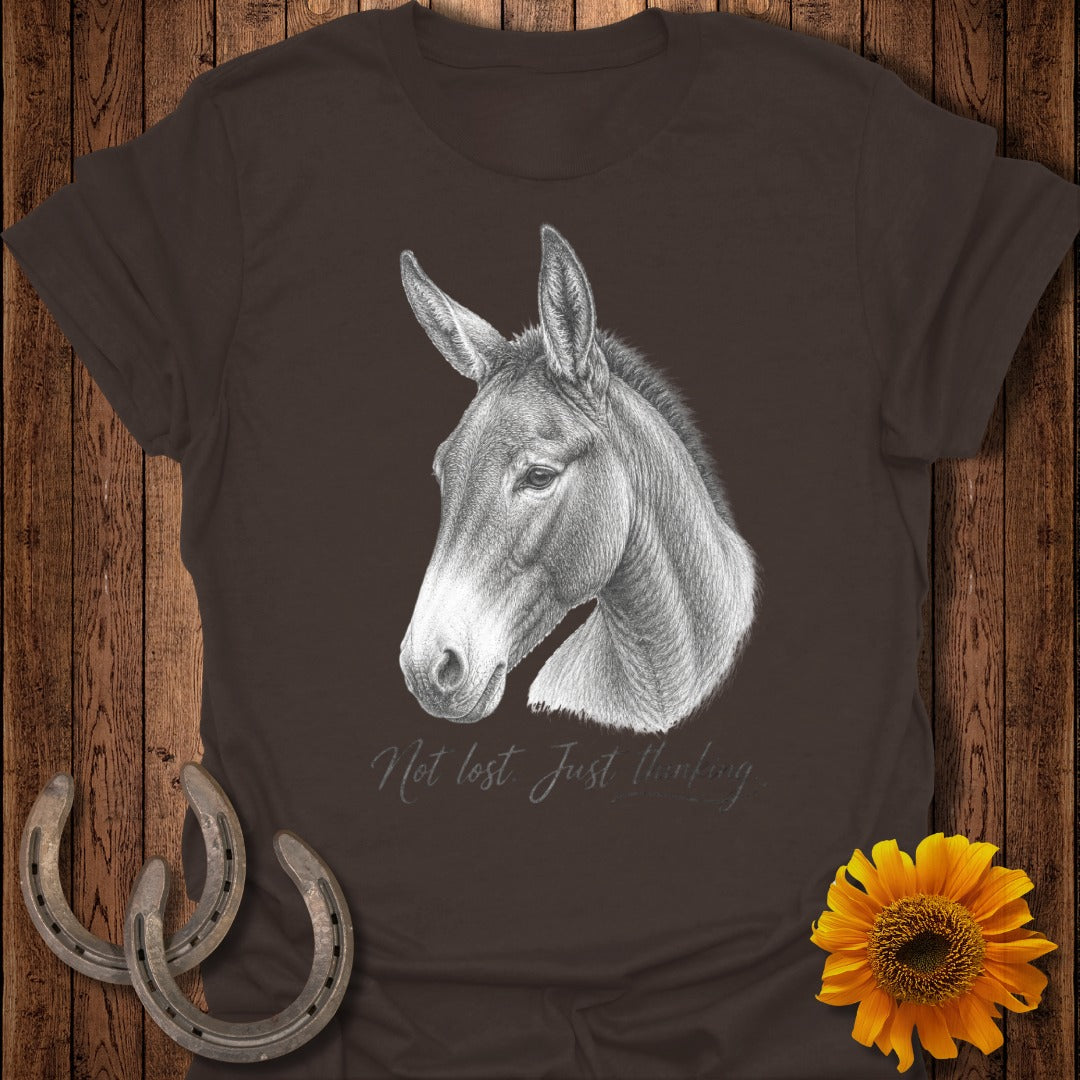Pencil drawing of a mule's head on a brown t-shirt with "Not lost. Just thinking."