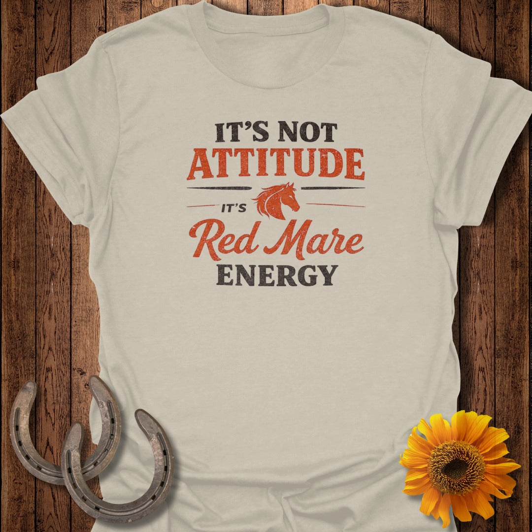 Light tan t-shirt with "It's Not Attitude, It's Red Mare Energy" slogan.