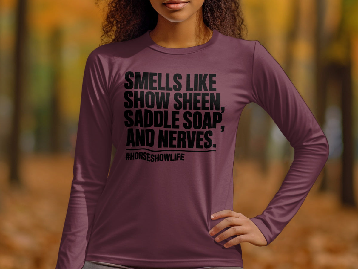 Maroon long-sleeved shirt with black text reading "SMELLS LIKE SHOW SHEEN, SADDLE SOAP, AND NERVES. #HORSESHOWLIFE".