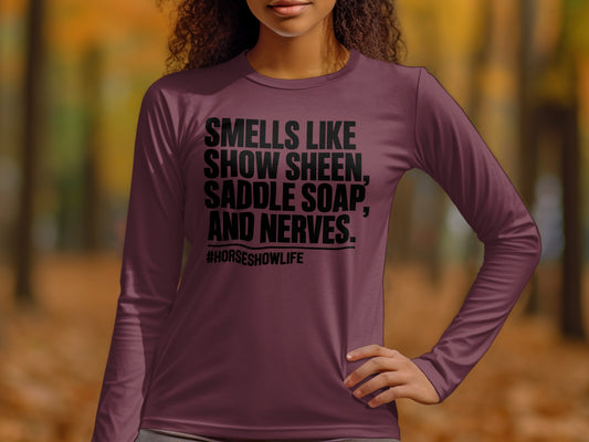 Maroon long-sleeved shirt with black text reading "SMELLS LIKE SHOW SHEEN, SADDLE SOAP, AND NERVES. #HORSESHOWLIFE".