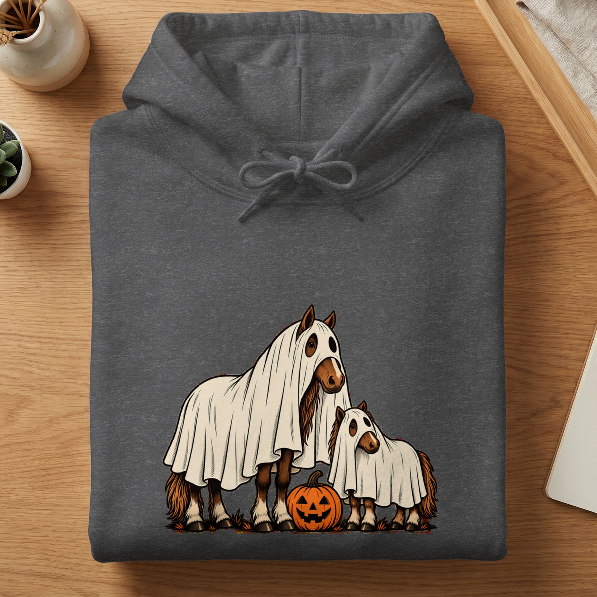Two horses in ghost costumes stand with a jack-o'-lantern.
