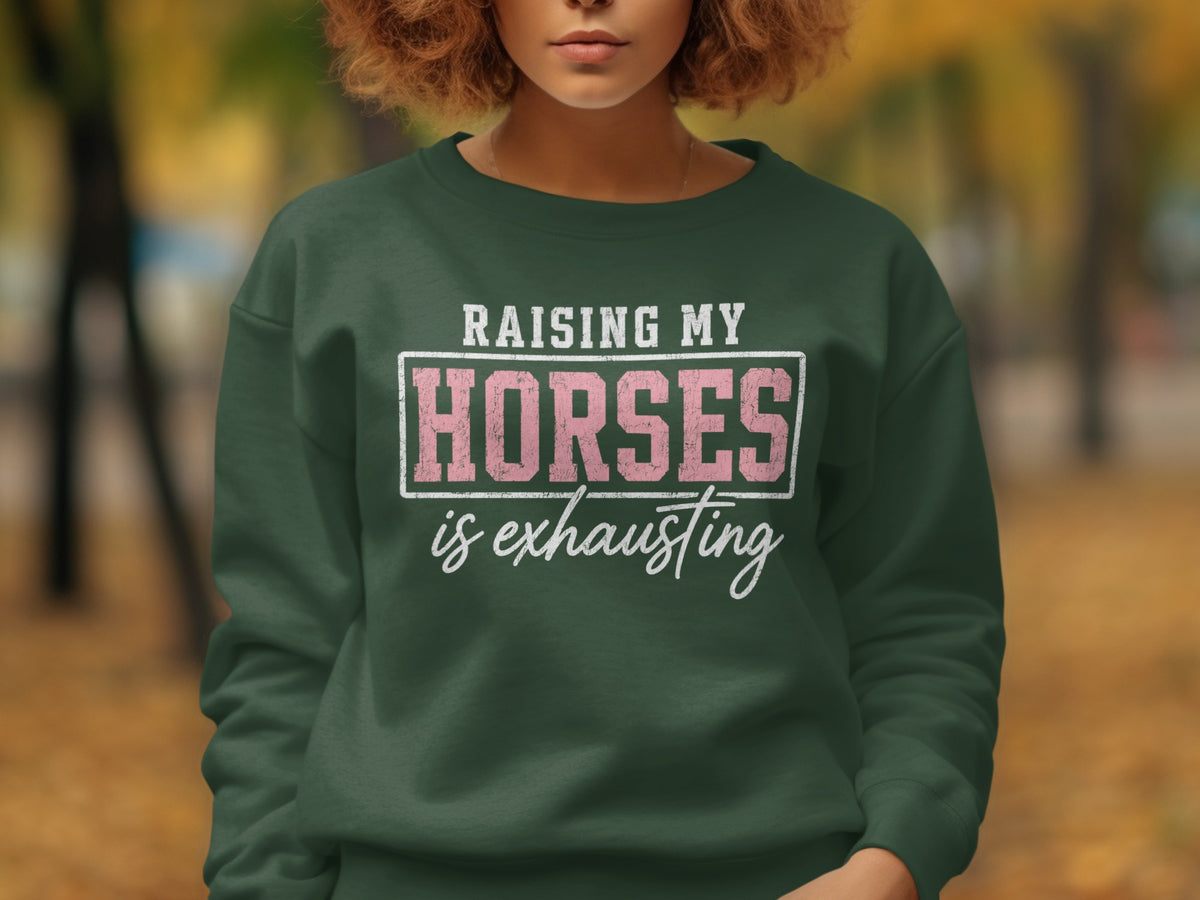 Green sweatshirt with white text "Raising My Horses is Exhausting".