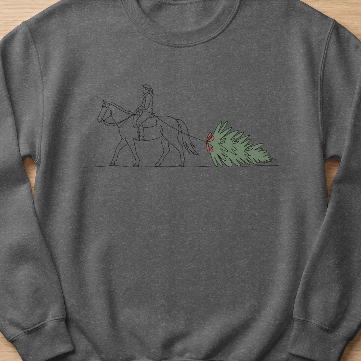 Line art of person on horseback pulling a Christmas tree with a red bow.