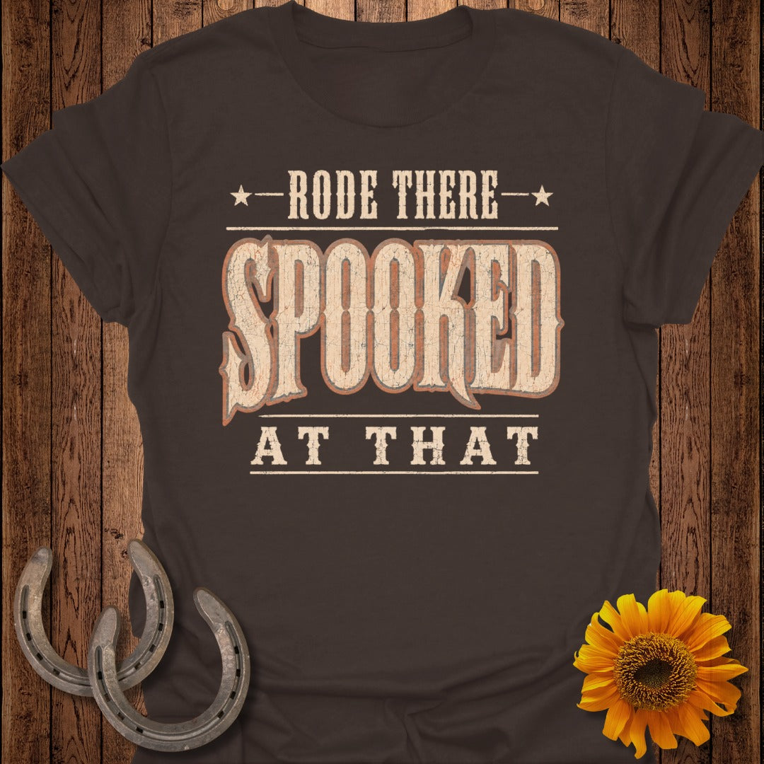 Brown t-shirt with "Rode There Spooked At That" text and horseshoe accents.