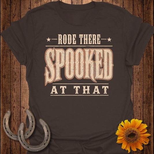 Brown t-shirt with "Rode There Spooked At That" text and horseshoe accents.
