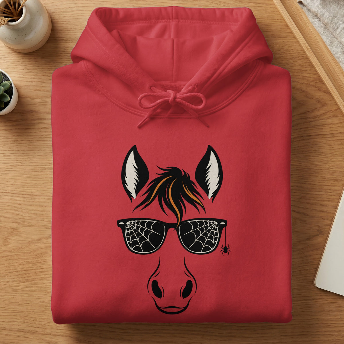 Red hoodie with a black horse face graphic, spider web sunglasses, and spider.