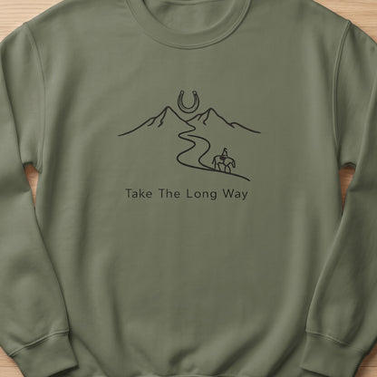 Olive green sweatshirt with mountain, horseshoe, and rider graphic and text "Take The Long Way".