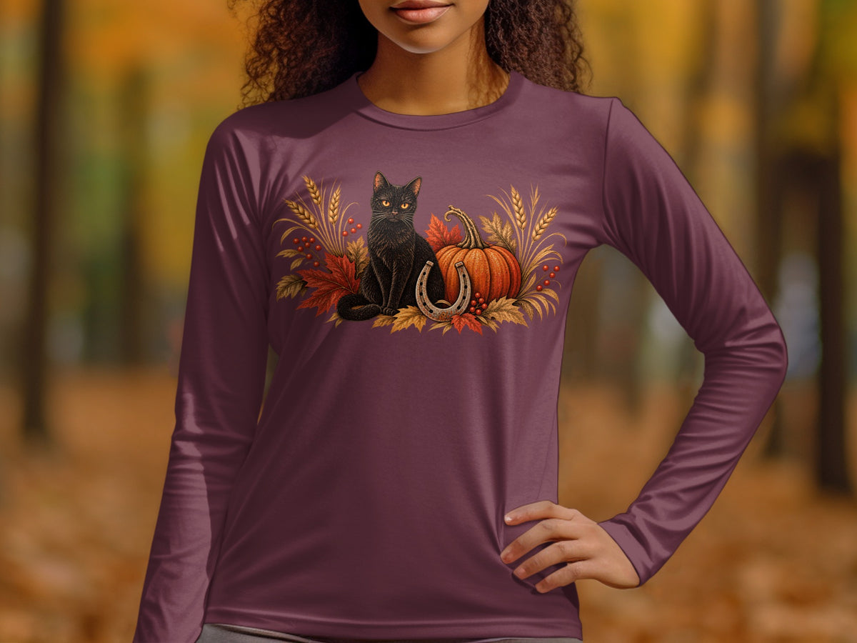 Black cat, pumpkin, and horseshoe with autumn leaves graphic on a long-sleeve shirt.