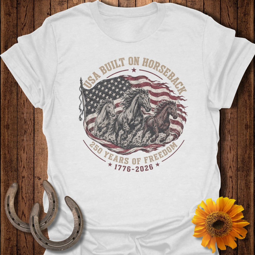 White t-shirt with horses running in front of American flag and "USA Built on Horseback" text.