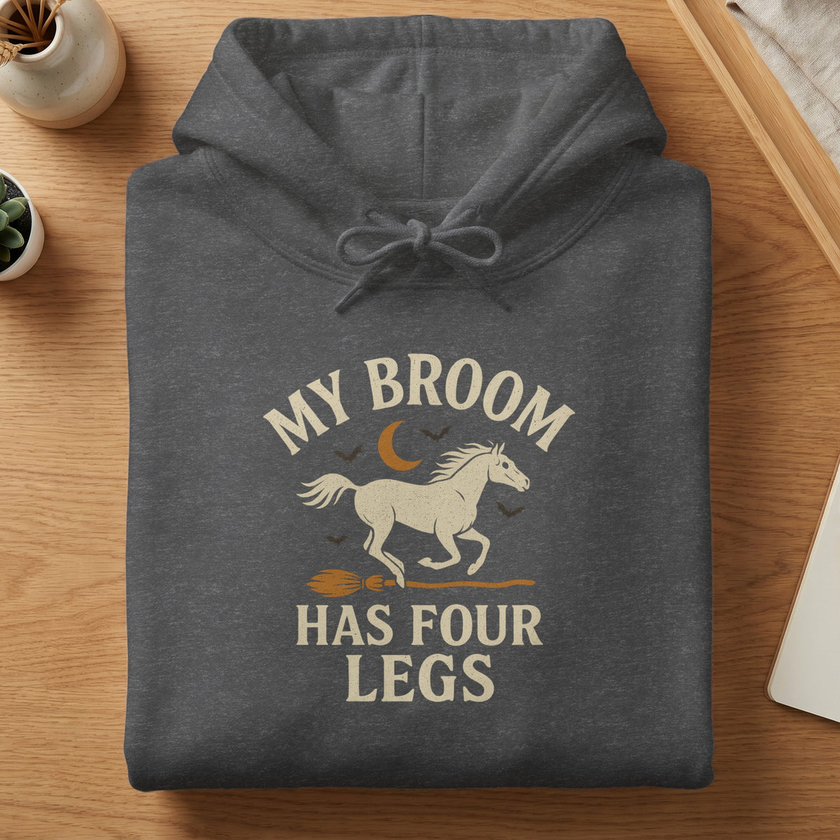 Dark gray hoodie with a white horse on a broomstick, text says "My broom has four legs".