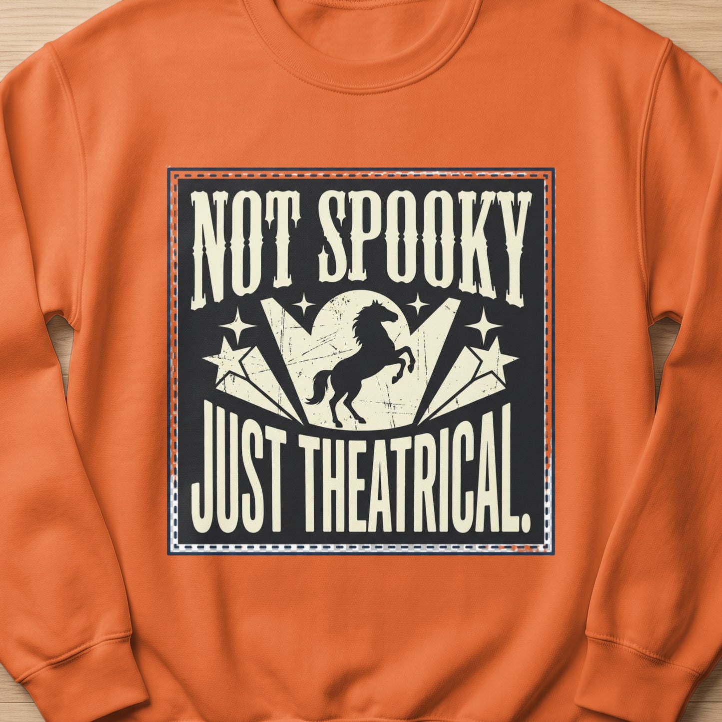 Orange sweatshirt with "Not Spooky Just Theatrical" text and horse graphic.