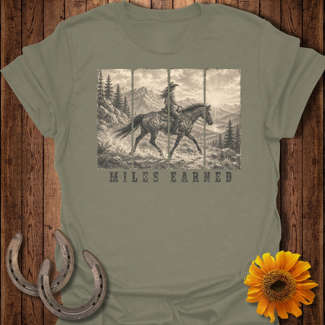 T-shirt with a vintage western scene of a woman on horseback and the text "MILES EARNED".